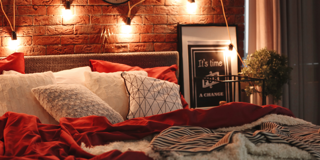 a cozy bed in front of exposed accent wall featuring hygge design
