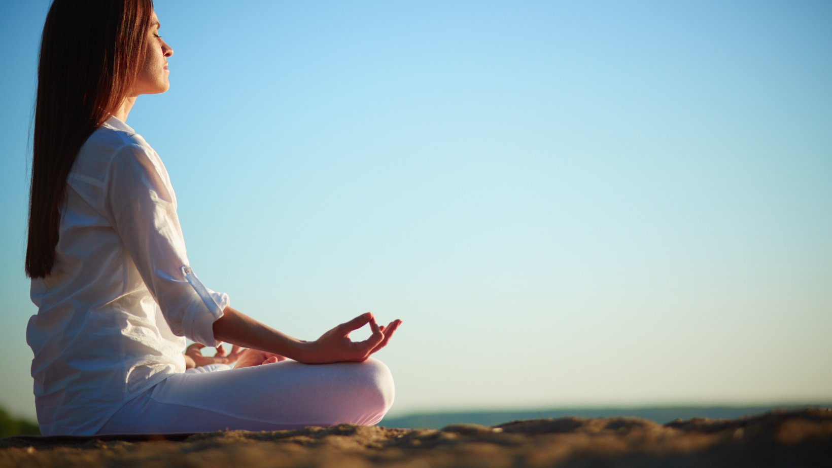 A woman sitting down and meditating