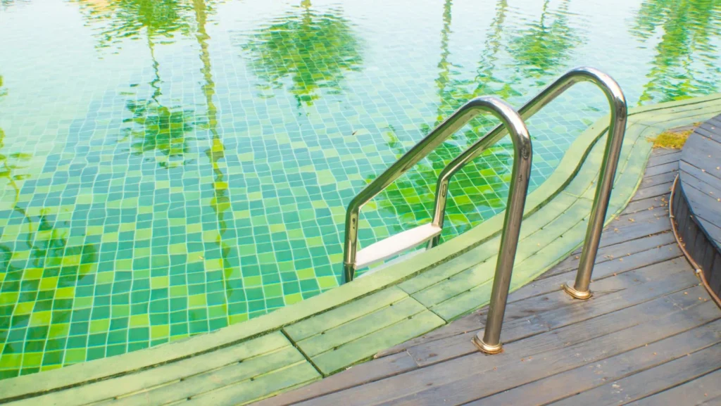 A swimming pool with teak flooring on the outside