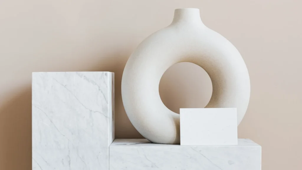 Decorative vase of ring shape with blank card on marble stand